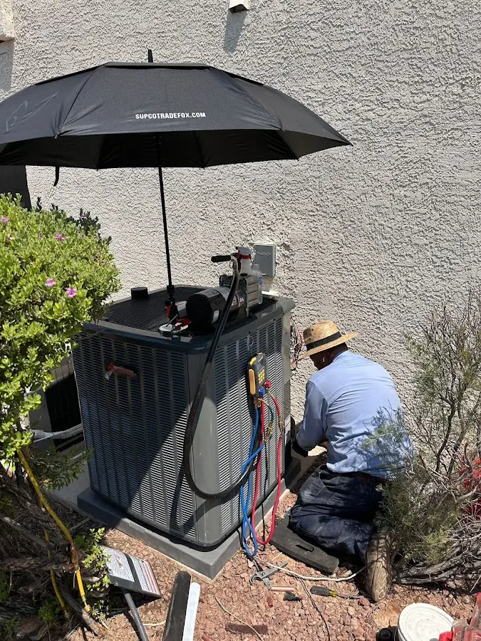 HVAC technician performing outdoor AC maintenance in Centennial