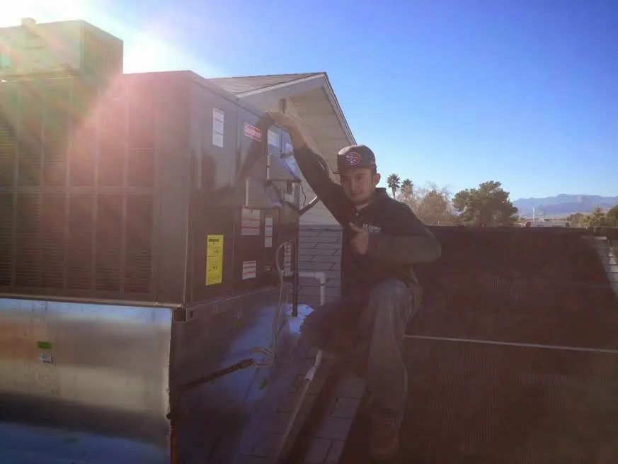 HVAC technician performing Heat Pump Repair on a rooftop unit in Centennial